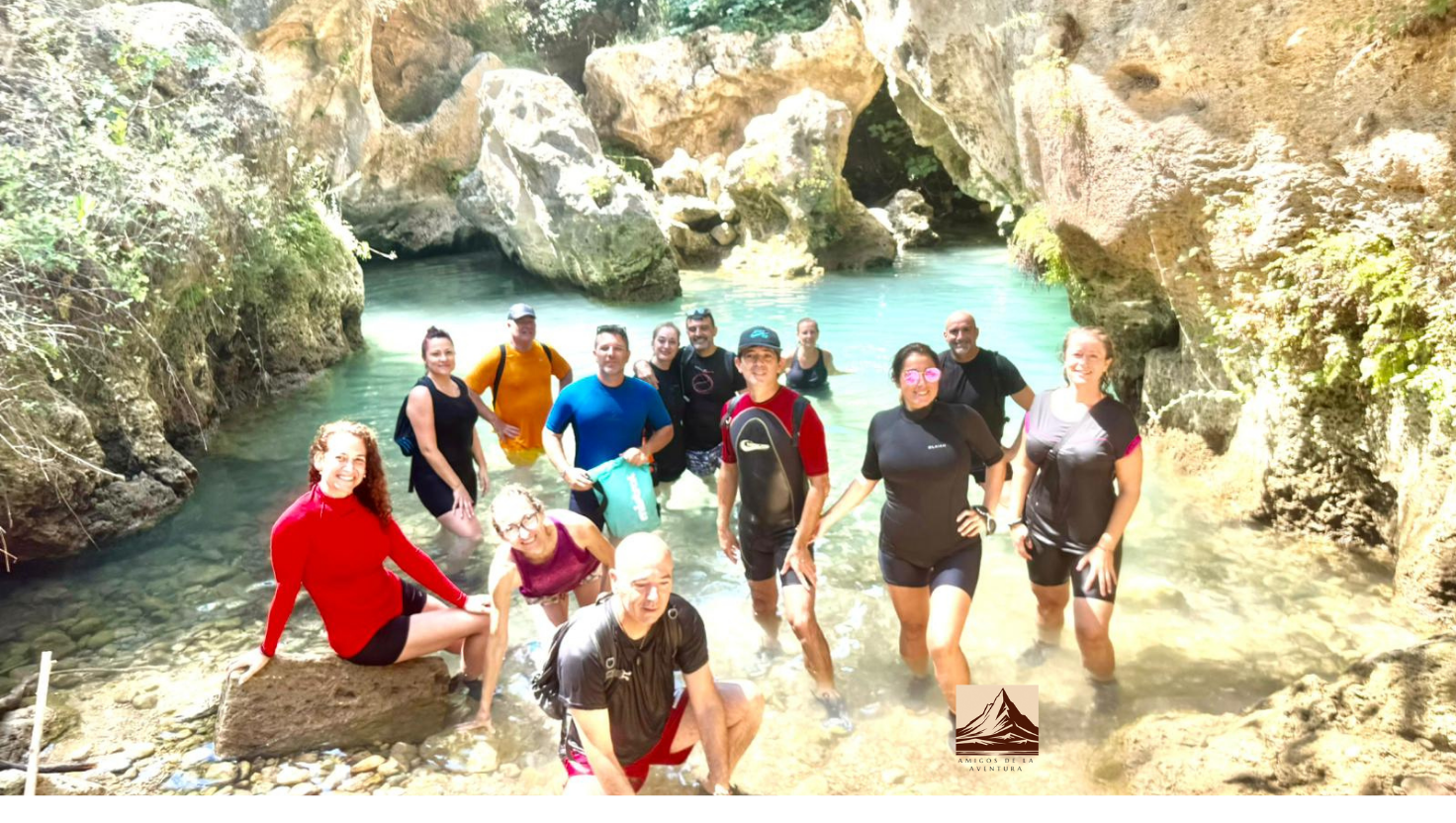 Imagen del grupo de senderismo en una ruta de barranquismo, se ve agua turquesa de fondo